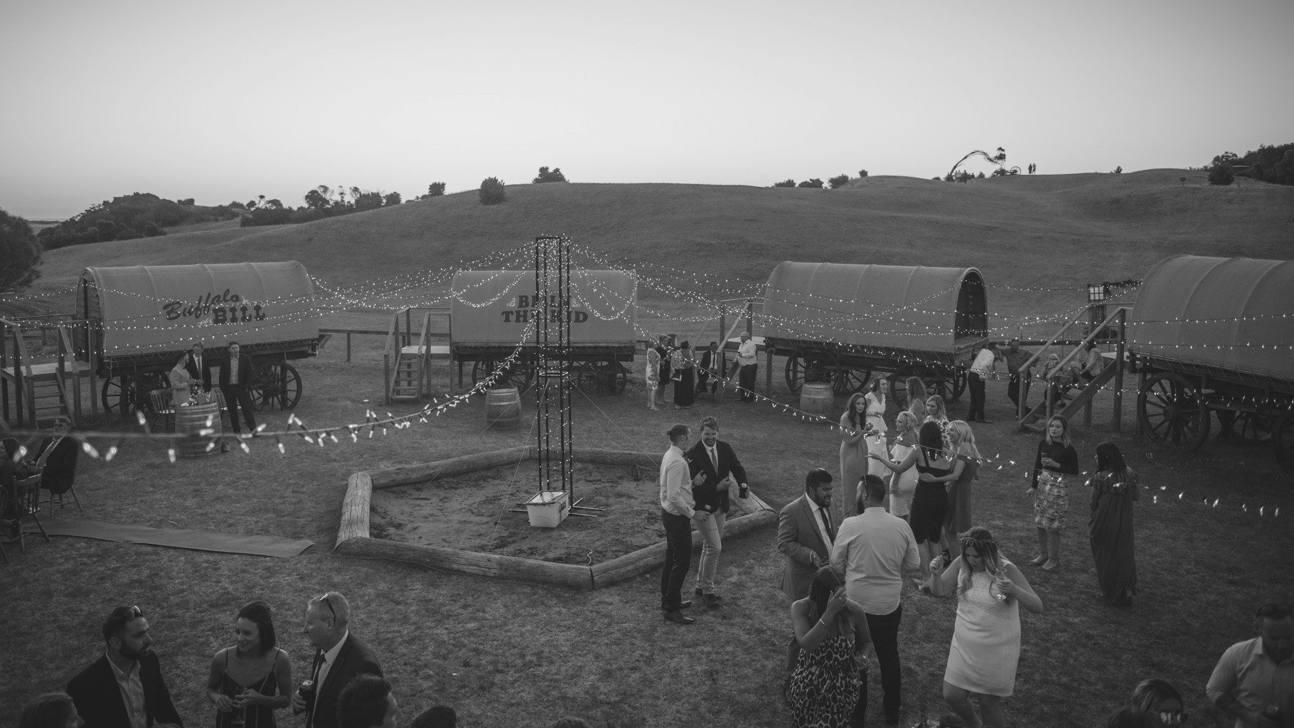 Weddings guests outside a circle of wagon carriages.